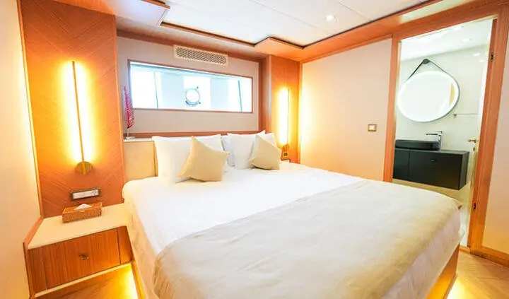 King of the Sea cabin with a large bed, white bedding, and wood accents