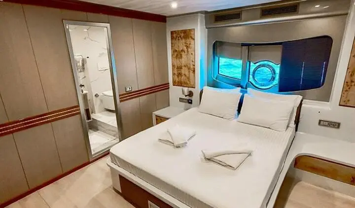 Angelo III cabin with double bed and neatly set pillows, cabin interior