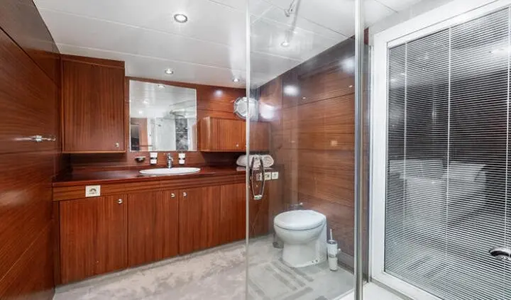 Master cabin with king bed, wood cabinetry, ensuite bathroom and tiled floor