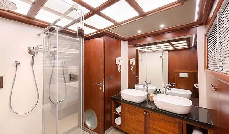 Lady Gita cabin: king bed, ensuite vanity, wood cabinetry, and bathroom