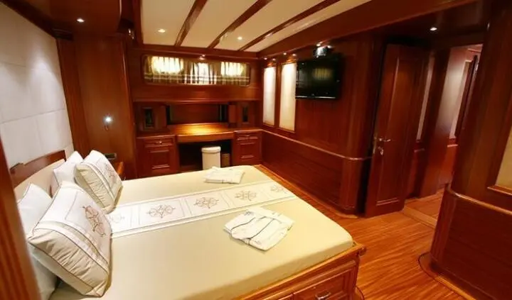 Master cabin with king bed, wood panels, ensuite, reading lamps, towels