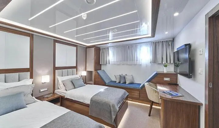 Twin cabin ensuite bed aboard Corsario yacht with two single beds and gray-blue decor