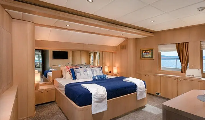 Grace yacht master cabin with king bed, blue throws, wood paneling, ensuite