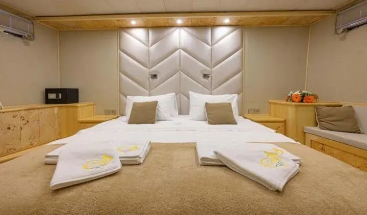 Belgin Sultan master cabin with two beds, tufted headboard, and built-in nightstands