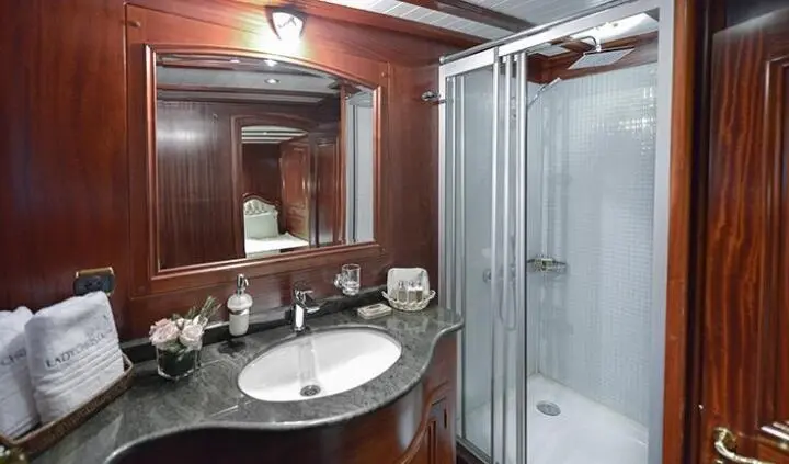 Master cabin with king bed, ensuite bathroom, wood paneling, vanity mirrors