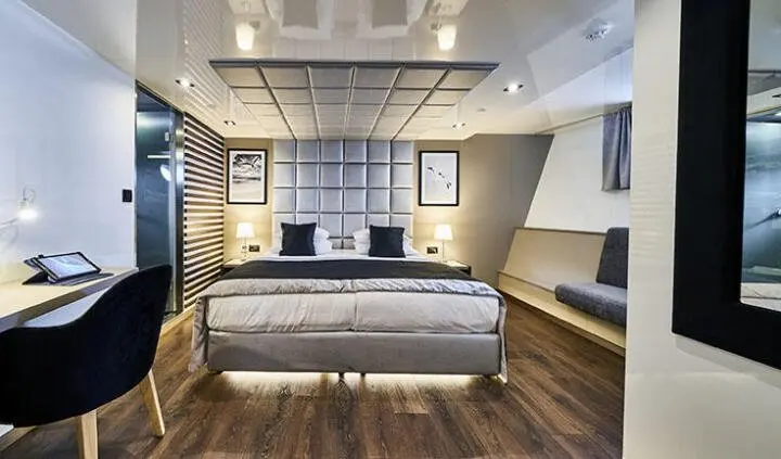 Master cabin with king bed, white headboard, and ensuite door visible