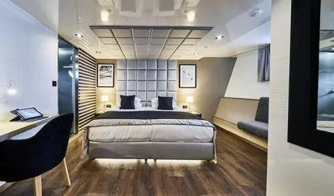 Master cabin with king bed, white headboard, and ensuite door visible