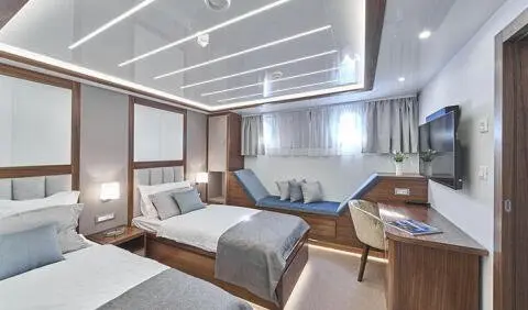 Twin cabin on Corsario yacht with two beds and wooden paneling
