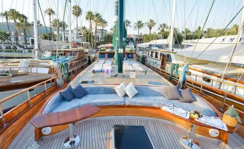 Wide deck with wood yacht seating area and cushions