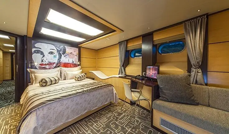 Navilux cabin with king bed, seating area, and wood finish interior