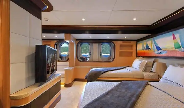 Meira yacht cabin with twin berths, wood cabinetry, windows, and bed linens