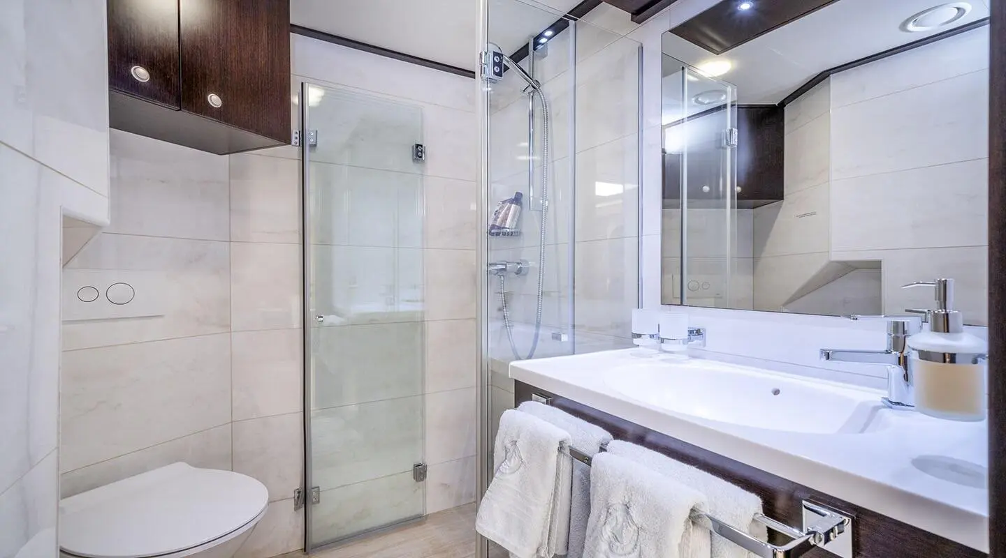 Navilux yacht bathroom detail: glass shower enclosure, sink, towel neatly hung
