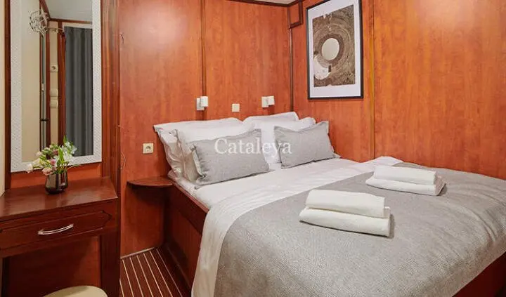 Cabin bed setup on Cataleya yacht with pillows and folded towels on bed