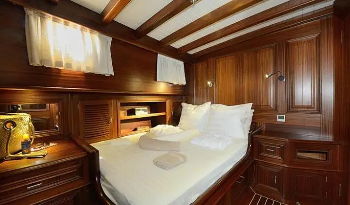 Cozy wooden cabin interior with two single beds on opposite sides of a small table