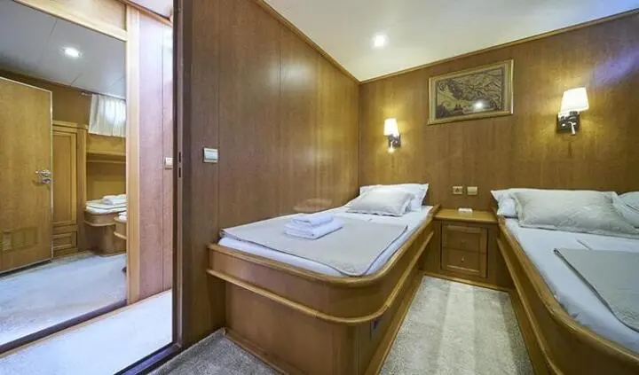Morning Star yacht master cabin with a large bed, wood paneling, and ensuite door