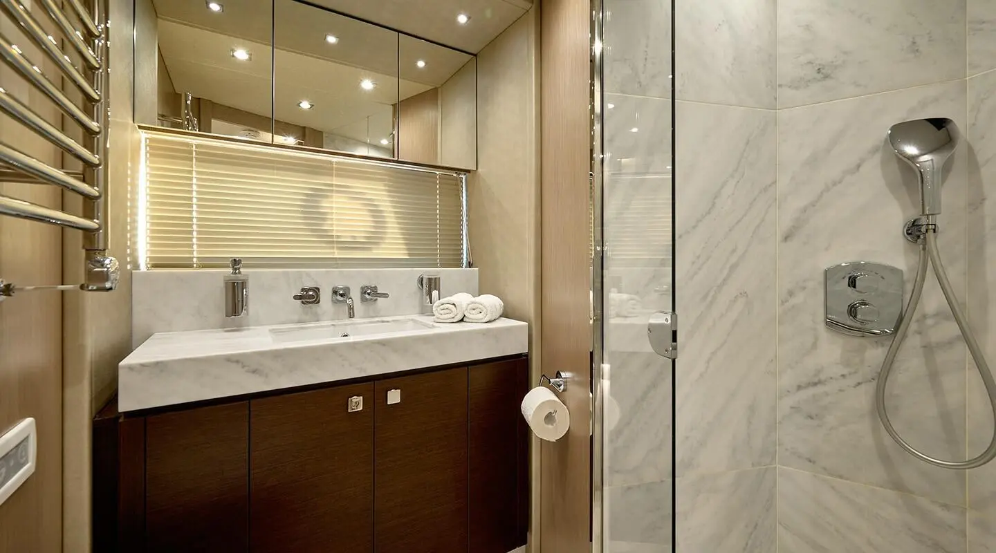 Luxurious yacht bathroom with marble walls, vanity mirror, and sink