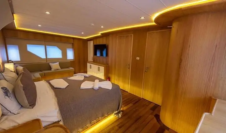 Master cabin with king bed, wood finish, built-in wardrobes, soft lighting