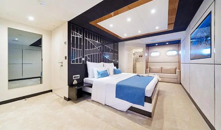 Acapella yacht cabin bed area with blue and white bedding and modern decor