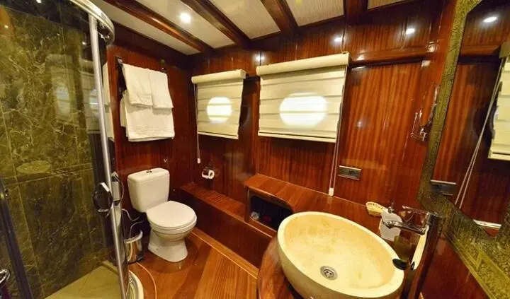 Lycian Queen cabin interior with wooden walls, round table, and seating