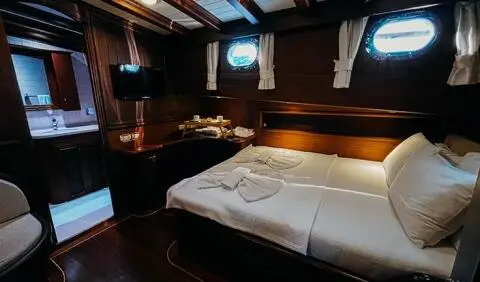 Wicked Felina master cabin with king bed, white linens, wood paneling, ensuite glimpse