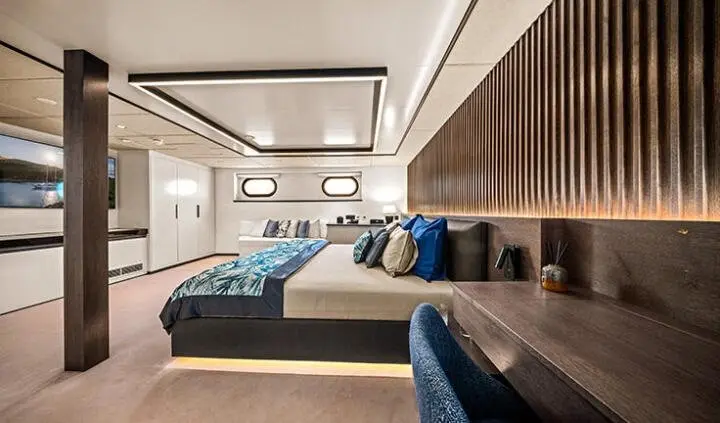 Master cabin with king bed, pristine white linens, and ensuite area on Anima Maris