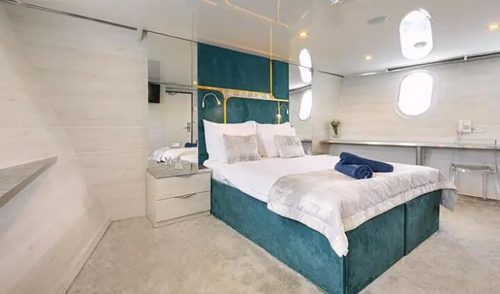Teak cabin with king bed on yacht Yolo, nautical decor and built-in storage
