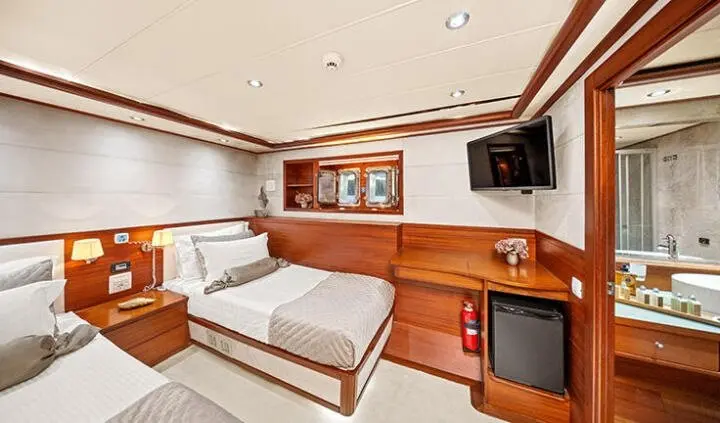 Twin cabin with king-size bed, wooden cabinetry, and ceiling lights