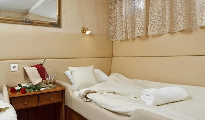 Twin cabin with two single beds and white linens on a yacht interior