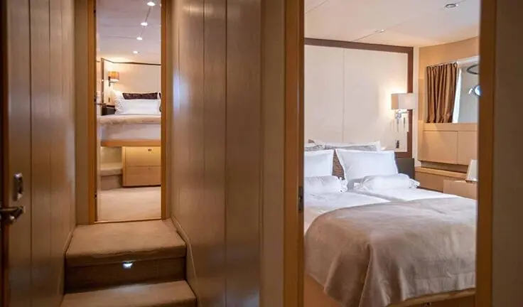 Master cabin with king bed, ensuite and soft lighting aboard Insieme yacht