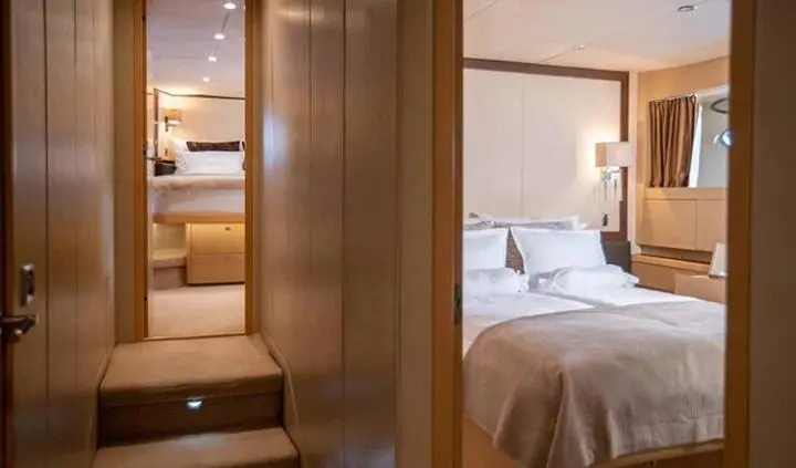 Master cabin with king bed, ensuite and soft lighting aboard Insieme yacht