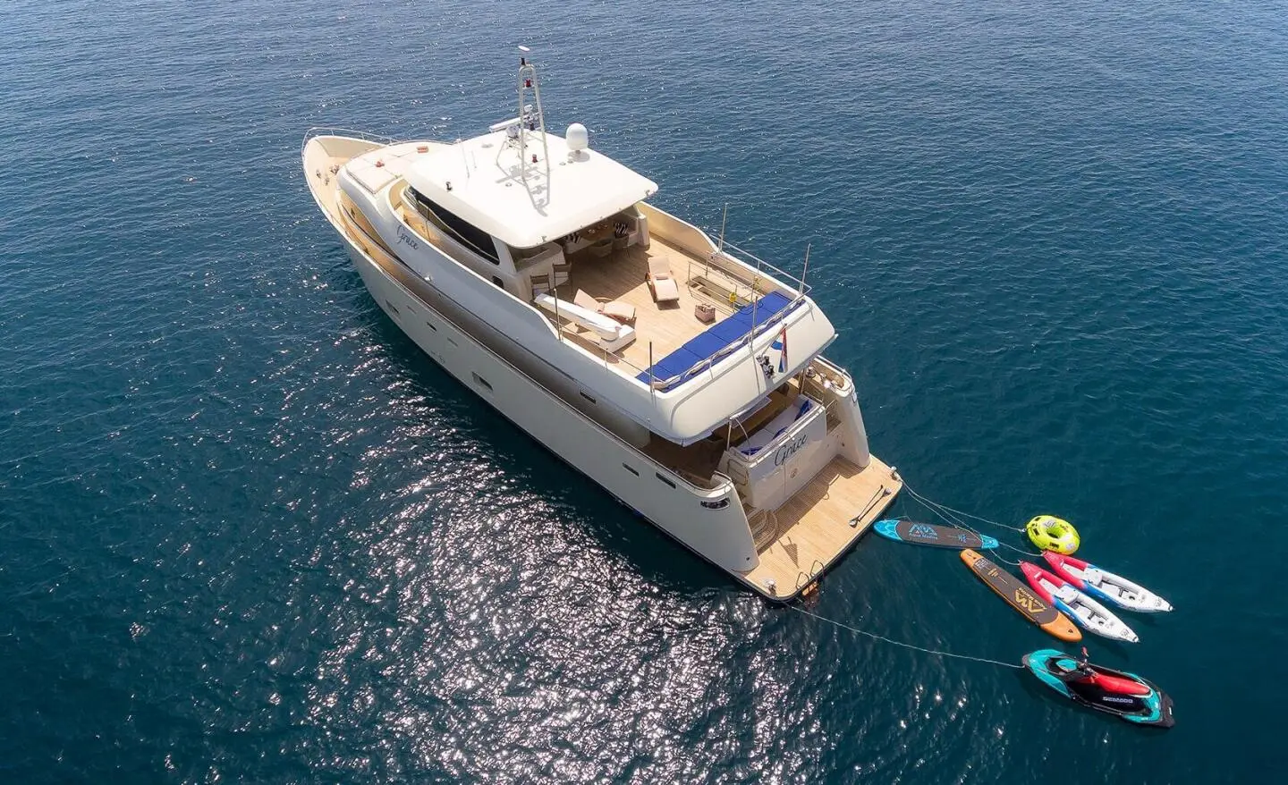Grace yacht anchored near calm blue sea at sunset, aerial view
