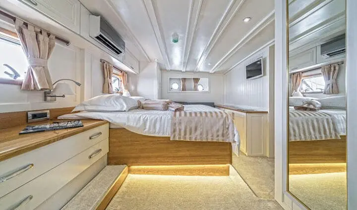 Maske yacht master cabin with king bed, ensuite view and warm lighting