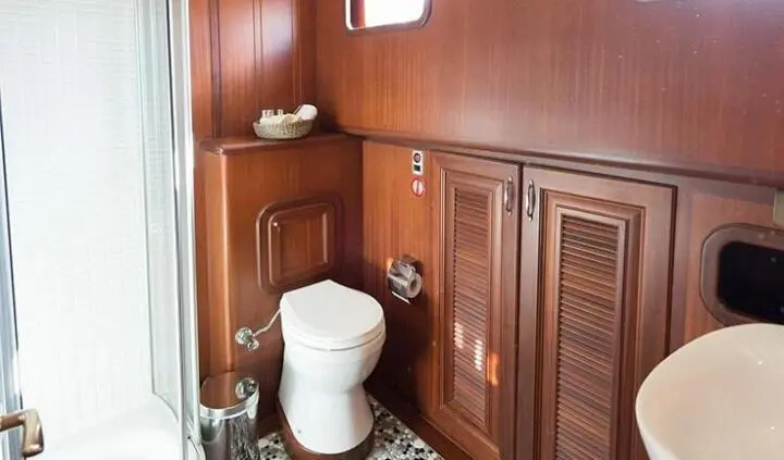 Guest cabin bed and ensuite area on Primadonna yacht, wood paneling