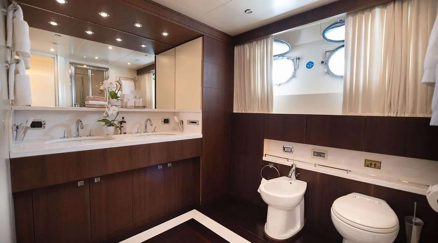 Interior bathroom on Pareaki II yacht with wooden vanity and toilet