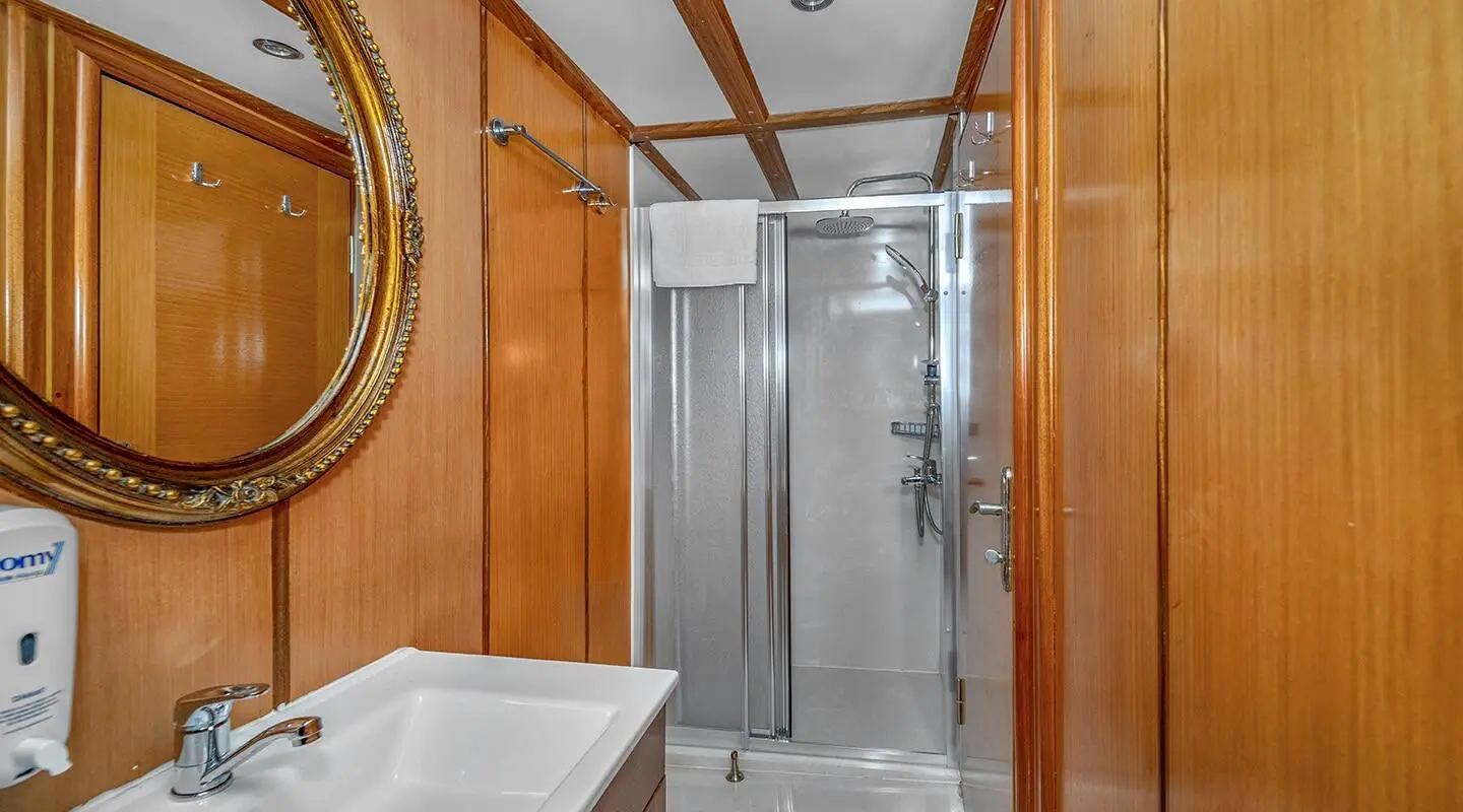 Luxurious yacht Tersane 8 interior: polished wooden walls and compact shower cabin
