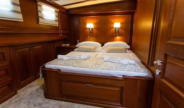 Dolce Vita master cabin with king bed and ensuite visible in wood-paneled room