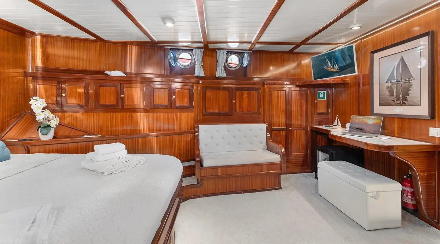 Luxurious yacht interior with wooden cabinets, seating, and sunlit deck view