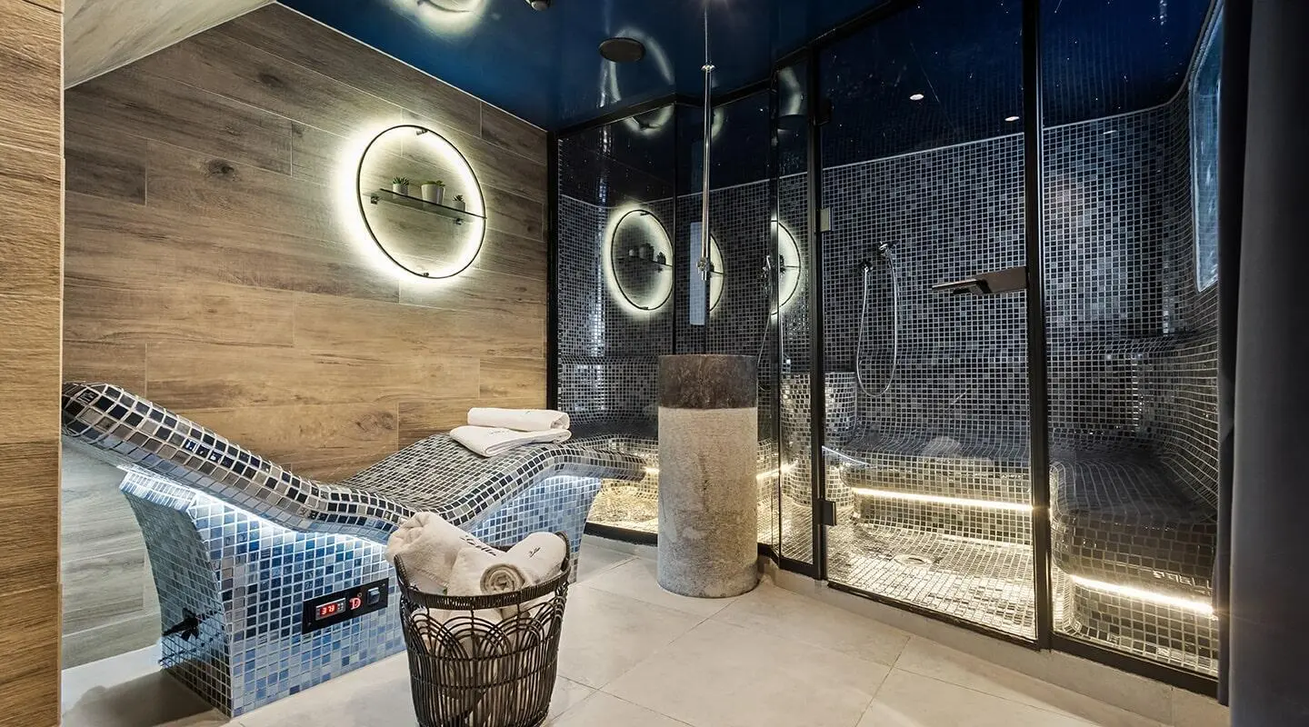Bella yacht interior with circular portholes, modern seating, and blue mosaic wall