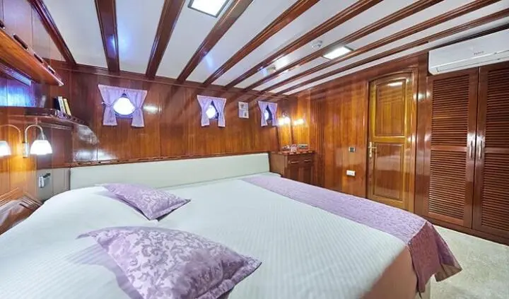 Stella Maris master cabin aboard a yacht with wood walls and bed
