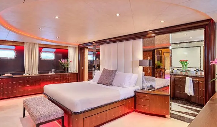 Mobius yacht cabin with king bed, white linens, and wood accents