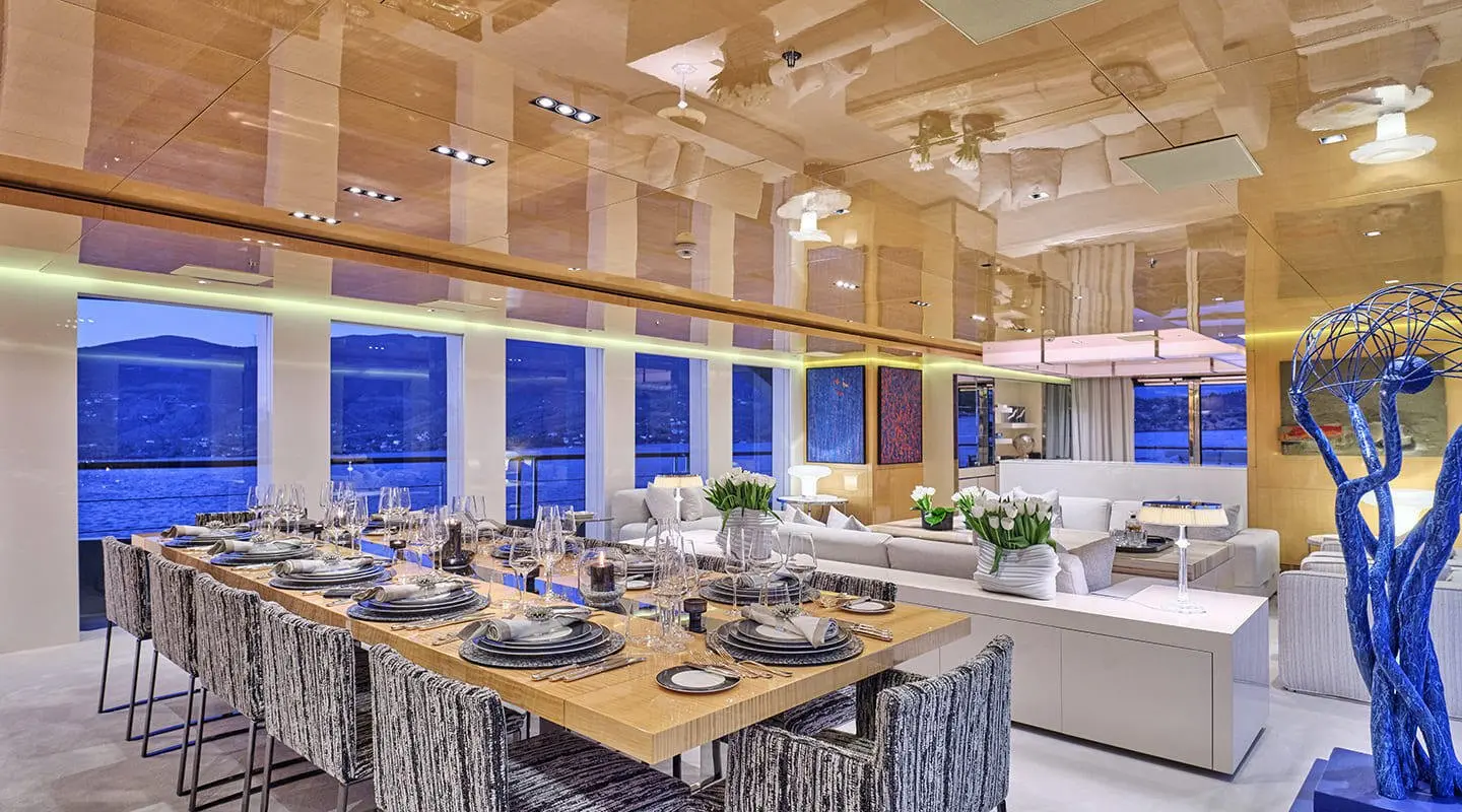 La Pellegrina 1 yacht dining area at sunset with table settings and chandeliers