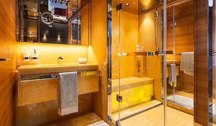 Takara One yacht cabin with king bed and ensuite bathroom, warm wood tones