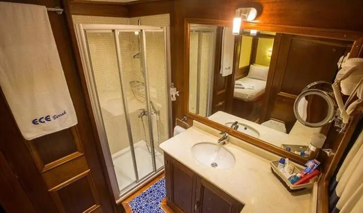 Master cabin with ensuite bath on Ece Berrak yacht, wood tones and mirror