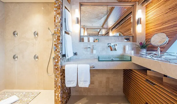 Cabin ensuite bathroom aboard Serenity yacht, view of sink, mirror, towels
