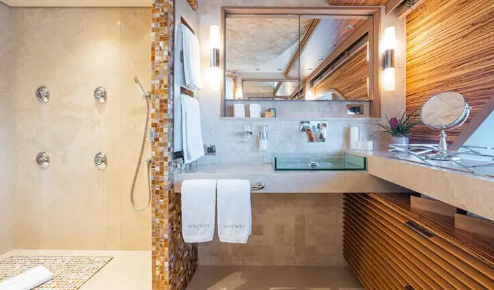 Cabin ensuite bathroom aboard Serenity yacht, view of sink, mirror, towels