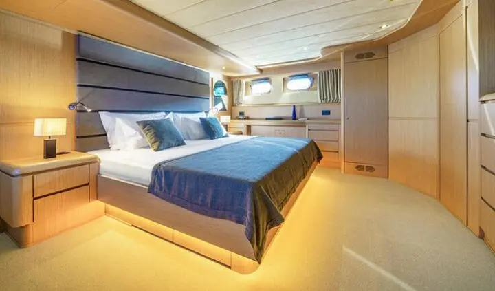 Phantom yacht master cabin with king bed, blue throw, ensuite door visible