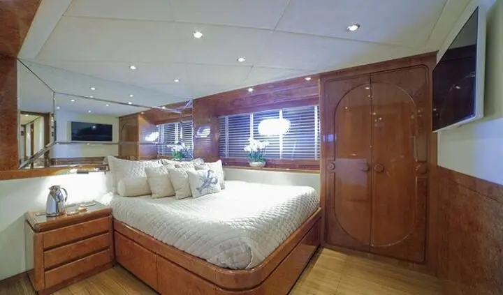 Master cabin with king bed, wood cabinetry, and ensuite bathroom door visible