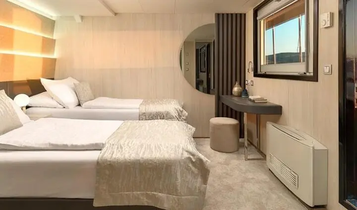 Twin-cabin luxury berth aboard Cristal yacht, neatly made beds and wood tones