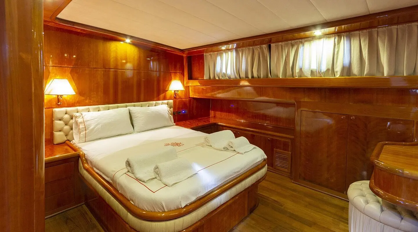 Luxurious cabin on a yacht with a bed, wood paneling, and ambient lighting