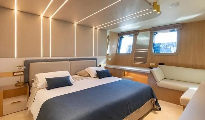 Master cabin with king bed, blue and white bedding, ensuite en suite visible